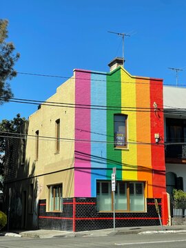 a rainbow painted building sitting in front of an apartment building