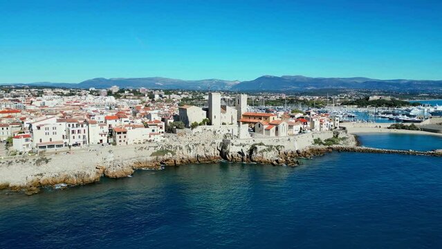 Drone shot of Antibes town with Chateau Grimaldi castle along sea on a sunny day in France