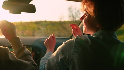 Youth, friendship, vacation travel at sunset, Concept. Female students driving in car listening to...
