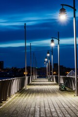 View of a wooden boardwalk illuminated by a streetlight