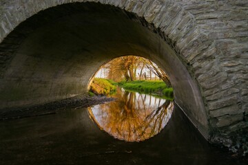 Old stone arch bridge above a tranquil river.