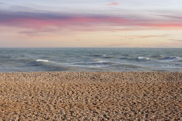Idyllic beach scene featuring a colorful sunset, with waves lapping gently against the shore
