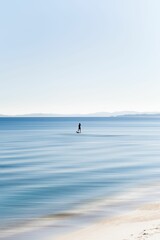 Obraz premium Person is surfing on a surfboard atop a large ocean wave in a sunny location