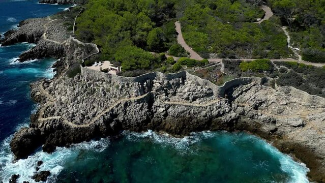 Aerial footage of Sentier du Littoral trail on Cap d'Antibes on a sunny day in Antibes, France