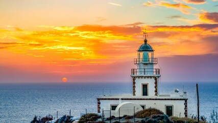 Fototapeta na wymiar View of Akrotiri Lighthouse against the backdrop of the vibrant sky at sunset. Greece.