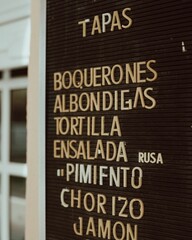 Exterior sign outside a Spanish restaurant with the day's meal options in bold lettering
