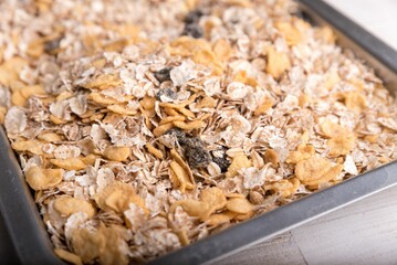 Close-up shot of a gray sheet pan filled with dry oatmeal