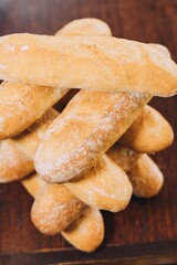 Freshly-baked bread resting on a wooden table top, with a light dusting of flour