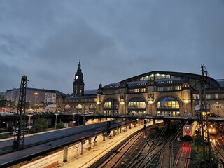 Fototapeta na wymiar Light-filled evening view of Hamburg Hauptbahnhof with commuter trains on the tracks.