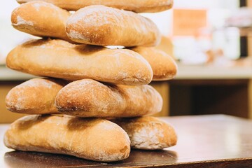 Freshly-baked bread resting on a wooden table top, with a light dusting of flour