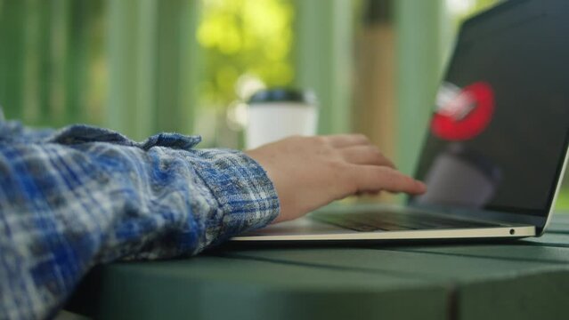 Woman is working with laptop in the green park co-working. Chatting with netbook outdoor close-up