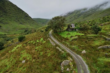 Aerial view of Molly's Cottage in County Kerry, Ireland, surrounded by lush green hills