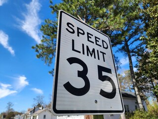 Closeup of 35 speed limit road sign under the blue sky with a blurry background
