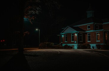 Nighttime shot of a residential street, illuminated by a lamp post.