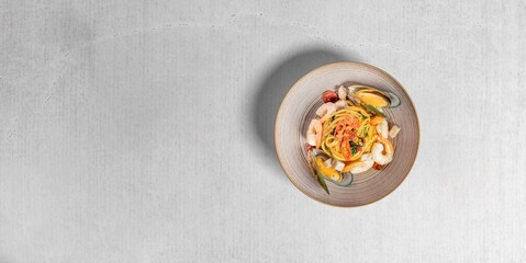 Top view of pasta with shrimps on a gray background