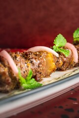Closeup of a kebab on a red marble background