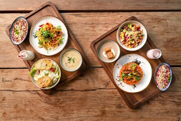 Top view of various delicious dishes served on a wooden table