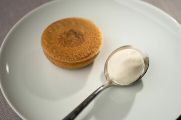 Closeup of a pudding served with a spoon of yogurt