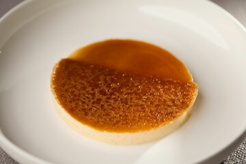Closeup of a pudding with caramel sauce on a plate