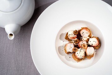 Closeup of a plate of shrimp on toasts with mushrooms