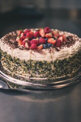 a cake with toppings on a plate sitting on a counter