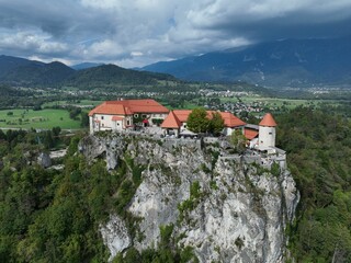 Idyllic castle perched high on a cliff overlooking a majestic mountain range