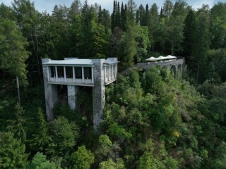 Fototapeta premium two tall buildings high up over the woods, surrounded by trees
