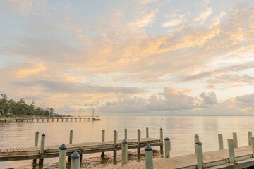 Closeup of a wooden dock stretching over a body of tranquil water at sunset in Fairhope