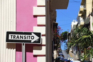 Obraz premium Black white direction sign near a pink building in San Juan, Puerto Rico