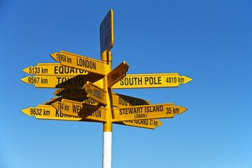 Post with yellow street signs showing various directions. Bluff,  New Zealand.