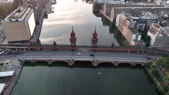 Drone footage of cars driving on Oberbaum Bridge crossing River Spree at sunset in Berlin, Germany