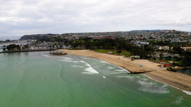 Drone shot of Doheny State Beach and the Marina with the cityscape of Dana Point in the background