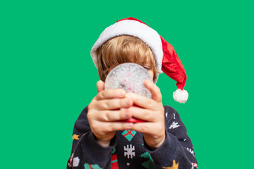Christmas boy in a holiday clothes. Happy child on a green background with a Christmas toys. Happy New Year. Merry Christmas!