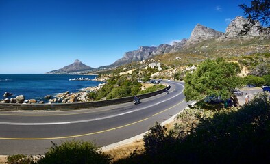 Curvy road surrounded by mountains. Lionshead and the Atlantic Ocean in Cape Town, South Africa.