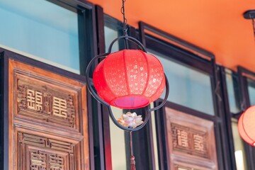 Striking red lantern suspended on the side of a structure