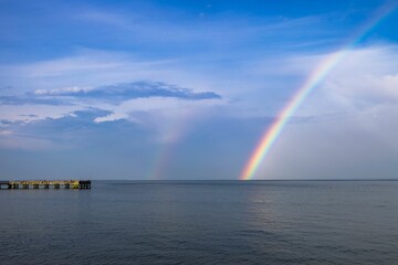 Naklejka na ściany i meble Stunning view of the Downs Park Fishing Pier in Maryland, USA with a rainbow in the backgroudn