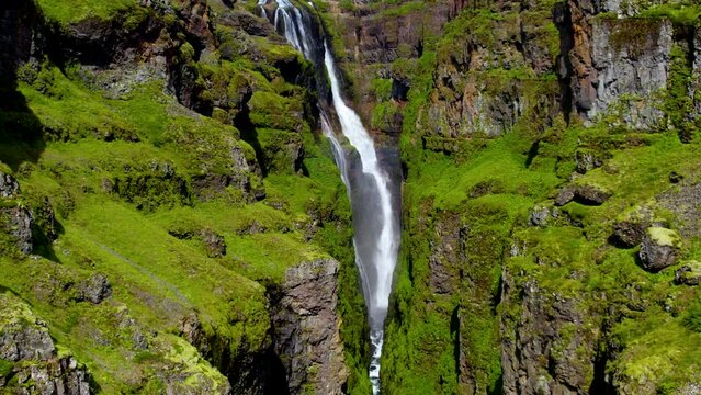 Aerial video of a beautiful waterfall flowing through the mountains