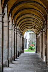 Obraz premium Majestic corridor featuring numerous grand arches and pillars crafted from stone