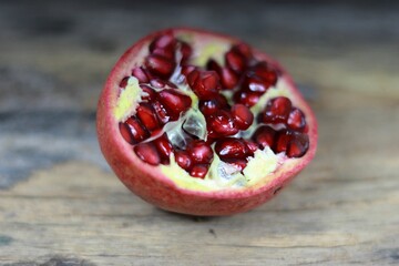 there is a pomegranate cut in half on a wooden table