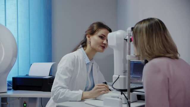 The ophthalmologist examines the patient's eye and then looks into the camera. Wide view footage