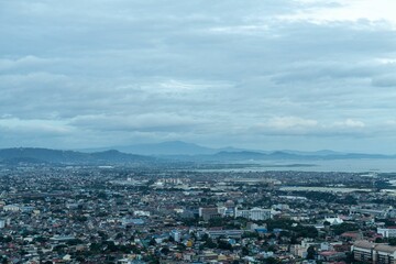 Aerial view of a city skyline features tall buildings and majestic mountain ranges
