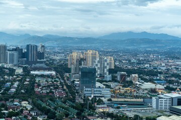 Aerial view of a city skyline features tall buildings and majestic mountain ranges