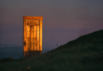 AI generated illustration of an isolated illuminated door on a hillside