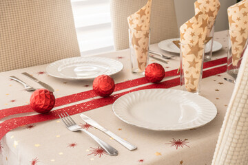 christmas table decorated with christmas balls christmas tablecloth and red ribbon