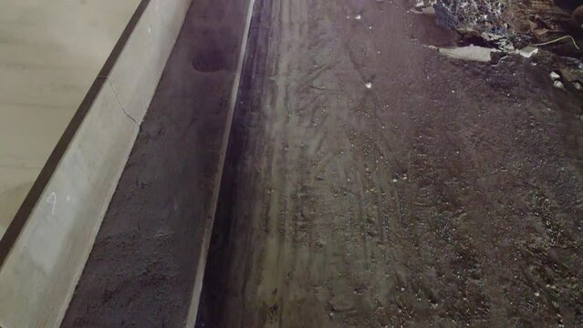 nighttime work group of excavators using hydraulic cutters and hammers to remove a bridge overpass, aerial view