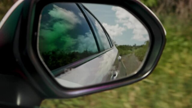 View of the road on the side mirror of a moving car