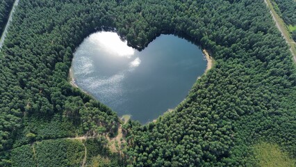 the heart shaped lake is surrounded by trees and a lot of clouds