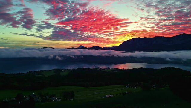 Drone shot panning over the countryside with a mountainous sunset sky background in Austria