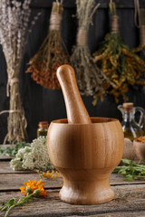 Mortar with pestle and calendula flowers on wooden table. Medicinal herbs