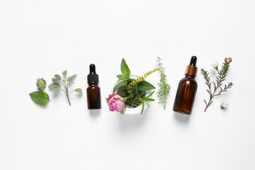 Bottles of essential oils, different herbs, rose flower and bud on white background, flat lay